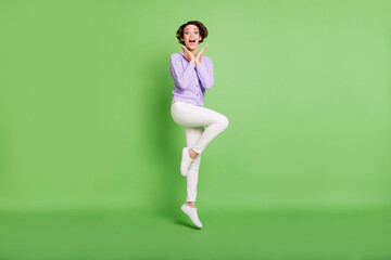 Full body portrait of astonished pretty person arms palms under face open mouth isolated on green color background