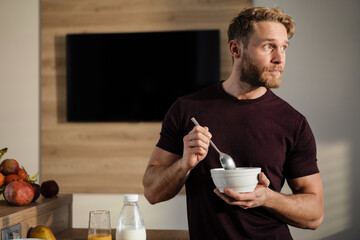 Attractive healthy young man having tasty breakfast