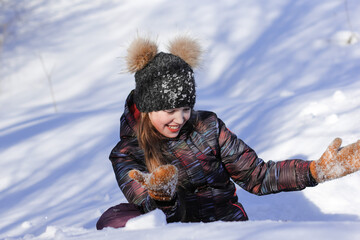 Fototapeta na wymiar A cute ten years old girl having fun on a winter day outdoors. Wintertime, entertainment, activity, childhood, holidays, christmas concept.