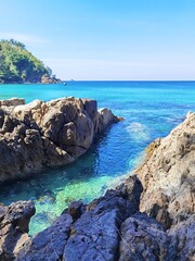 Green and blue water in lagoon around the cliff.