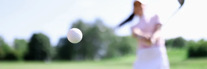 Fotobehang Golf ball against background of hitting woman closeup. Active healthy lifestyle concept © H_Ko