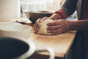 Obraz na płótnie Canvas Female hands preparing homemade bread. Elderly woman in kitchen knead the dough until it is smooth.