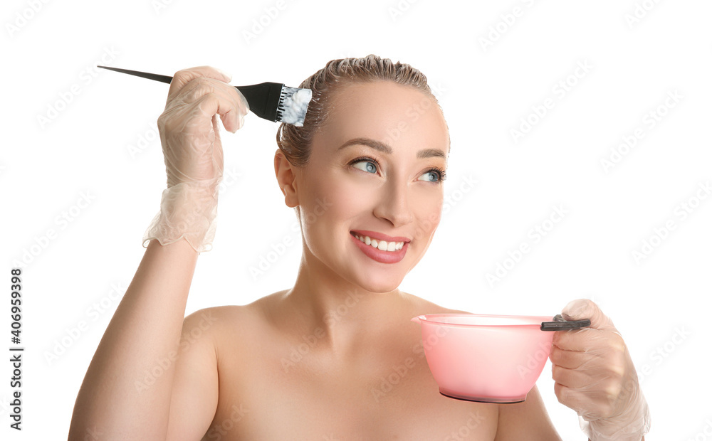 Canvas Prints Young woman applying dye on hairs against white background