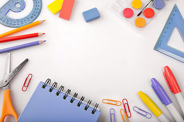 Children education, accessories, school supplies, colored pencils and a notebook in trendy colors on a white background with space for your text. Schoolchildren creativity concept and back to school 