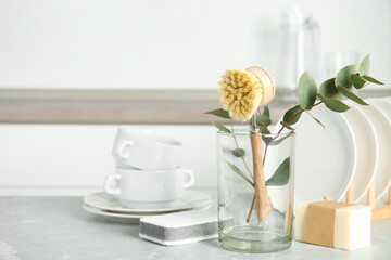 Cleaning tools on grey marble table indoors, space for text. Dish washing supplies