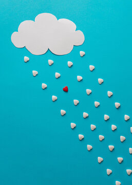 Cloud and rain in shape of hearts with one red drop.  Minimalist concept.