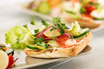Quick and healthy food recipes. Salad with salmon, vegetables and herbs on Italian ciabatta bread. Mediterranean dish recipes. Selective focus. Close-up