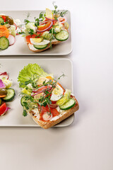 Quick and healthy food recipes. Salad with salmon, vegetables and herbs on Italian ciabatta bread. Mediterranean dish recipes. Top view. Copy space. Vertical shot