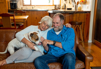 Couple relaxing at home and loving their pet. Positive image of life at home and New Normal