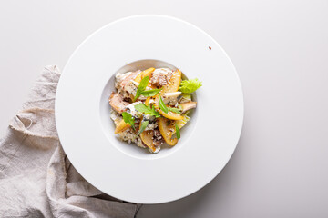 Quick and healthy food recipes. Salad with vegetables, herbs, turkey sous vide meat, caramelized pear, blue cheese with sesame dressing on white plate. Mediterranean dish recipes. Top view. Copy space