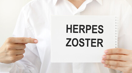 Doctor holding card in hands and pointing the word HERPES ZOSTER