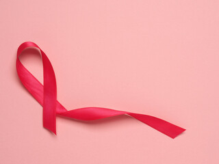 Pink ribbon curl on a pink paper background ,symbol for Liver Cancer awareness, World Cancer Day