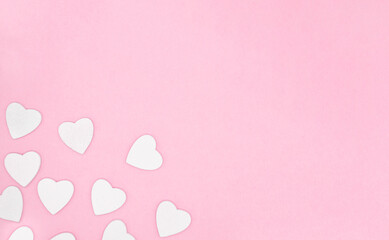 Wooden white hearts on soft pink color background, border, copy space. Valentine day concept for design.