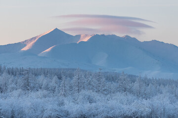Evening landscape of snow-capped mountains and trees. Along the Kolyma highway To the coldest place on Earth - Oymyakon. - 406963778
