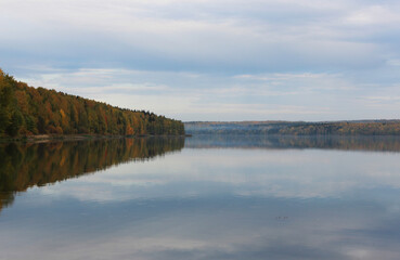 the autumn forest is reflected in the lake