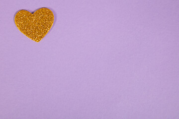 beautiful yellow heart on purple background, love concept, top view 