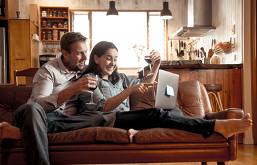 Fototapeta premium Couple chatting online cheering in virtual party with family and friends. Life at home, New Normal.