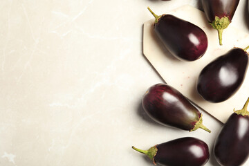 Raw ripe eggplants on light table, flat lay. Space for text