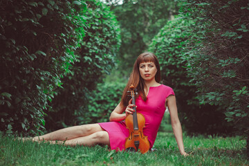Naklejka na ściany i meble beautiful girl with violin in green grass
