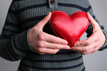 guy in jacket holding a red heart model in his hand, a symbol of love, concept of confession,...