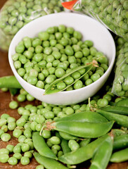 fresh green pea in bowl on wooden background