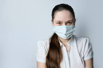 girl in white blouse and a medical mask holding heart model in her hands, symbol of love, concept of confession, Valentine's Day, cardiology