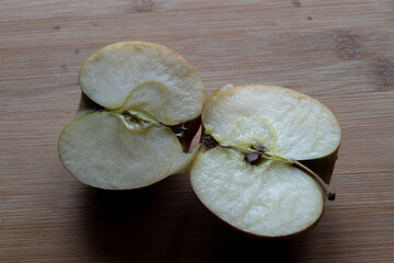 Two yellow apples on an old wooden background. Top view. Copy, empty space for text. An apple cut...
