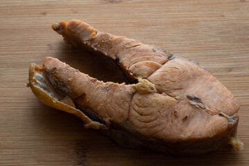 grilled salmon steak slices on wooden cutting board. Red fish steak on the table. Red raw fish steak on the table. Chum salmon on the table. Fried fish on the table