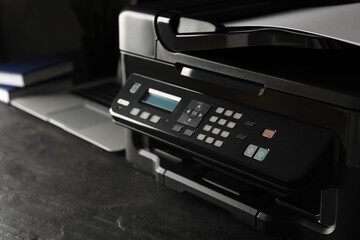 Closeup view of new modern printer with control panel on black table