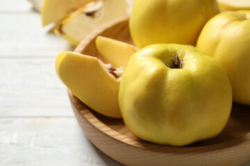 Fresh ripe organic quinces on white wooden table, closeup