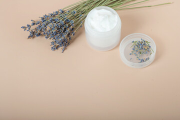 Obraz na płótnie Canvas body cream with lavender on a beige background.