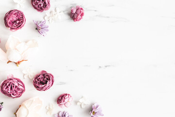 Flowers composition. White and purple flowers on marble background. Flat lay, top view