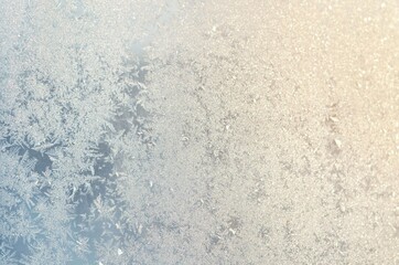 Light blue frosty patterns on the glass as a background, selective focus.