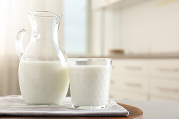 Delicious fresh milk on wooden table indoors. Space for text
