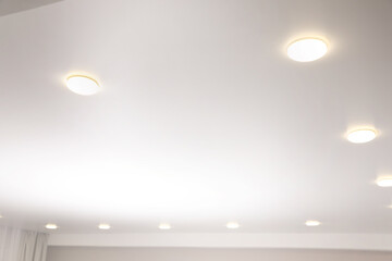 White stretch ceiling with spot lights in room, low angle view - obrazy, fototapety, plakaty