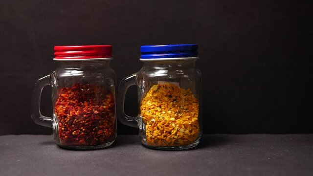 Kitchen utensils glass jars with dry spices. Sauce, curry, dried tomatoes