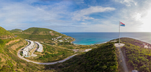 Landscape of the Caribbean island of St.Maarten. Isolate St maarten flag on top of a hill. 