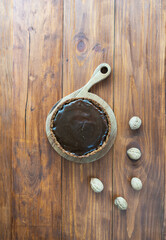 Tofu cake with salted caramel on a wooden table. Sugar, gluten and lactose free. Vertical orientation, top view.