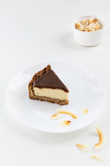 A slice of tofu cake with salted caramel on a white plate. Sugar, gluten and lactose free.
