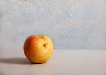 The funny apple lies on a light background. Healthy food concept. Minimalism. Copy space.