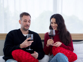 Portrait of couple drinking wine in the bedroom