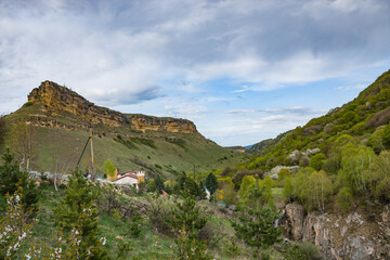 Beautiful mountain scenery. Mountains covered with green trees with residential settlements. In Kabardino-Balkaria. Of the Russian Federation.