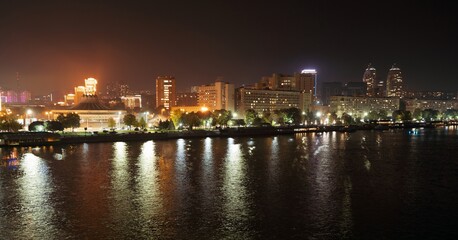 Fototapeta na wymiar Big Dnieper river in the huge night bright city of Dnipropetrovsk in Ukraine