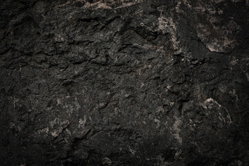 Black rough stone wall texture for background or wallpaper.