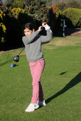 young girl inthe golf course drive swing