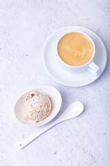 Homemade ice cream with chocolate chips in a bowl. One ball of ice cream and a cup with coffee. Close-up.