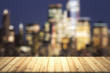 Table top made of wooden dies with blurry city view at dusk on background, template