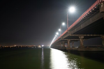Bottom view of a beautiful bright long bridge over the big beautiful Dnieper river