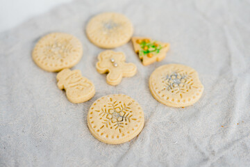 Traditional almond cookie with sugar, spices, and vintage rolling pin on rustic, on natural linen background.