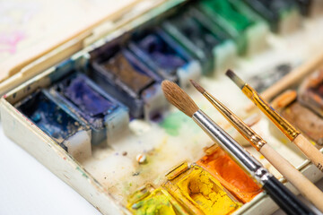 Top view of Work Process Blank Watercolor Paper pad, Watercolor Painting Supplies, Brushes and Colorful Pencil. Creation process of watercolor painting. Copy space. © alipko